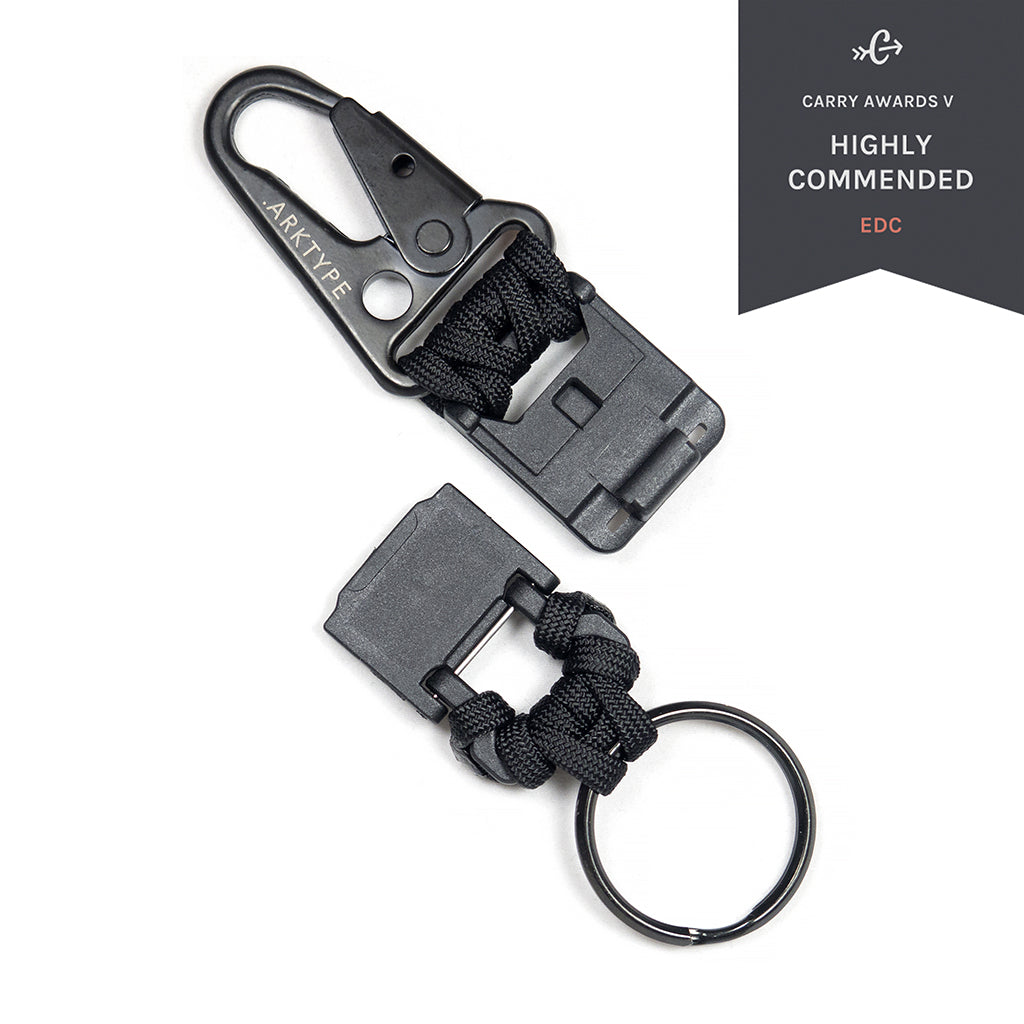 Grey-black keychain with matt patinated surface, metal arrow